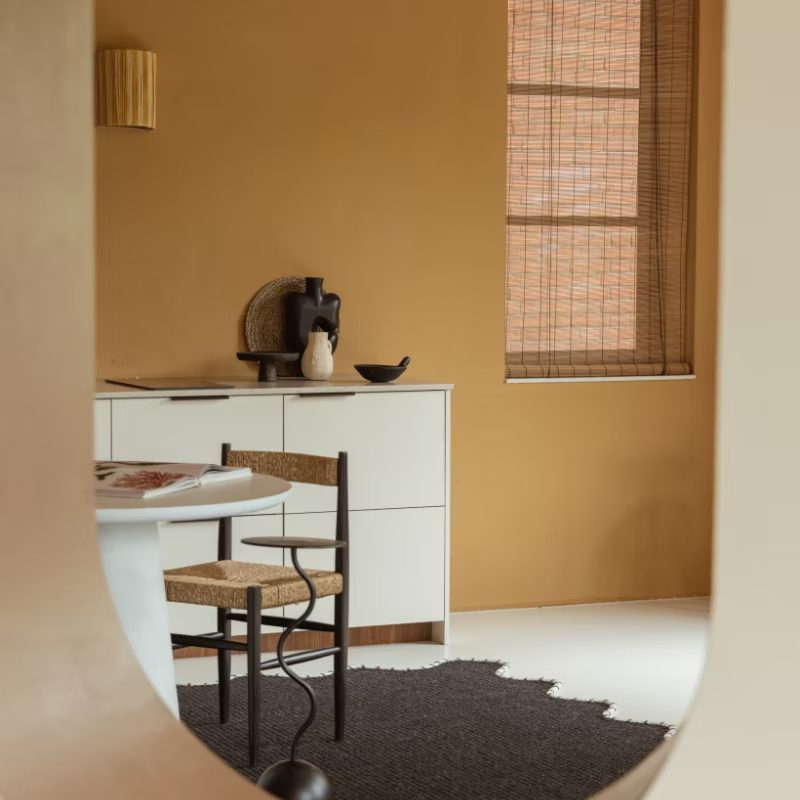 Doorkijk naar een keukenhoek met stoel en tafel